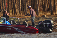 image of couple taking picture of rainy river walleye