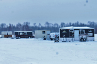 image of ice fishing shelters on frozen lake
