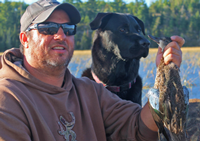 image of Jeremy Taschuk with Black Lab and Greenwing Teal