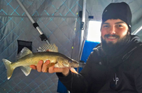 image of ice fisherman holding walleye