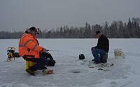 image of ice fishermen with perch on the ice