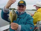 Greg Knox poses while John Donahue reels in another Cutfoot Sioux Bluegill