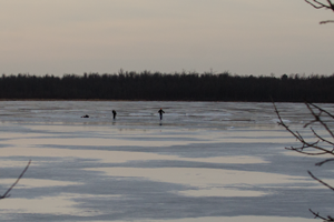 image of ice fishermen on melting lake