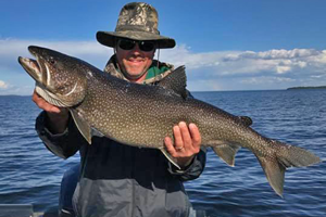 image of kris clusiau with big lake trout