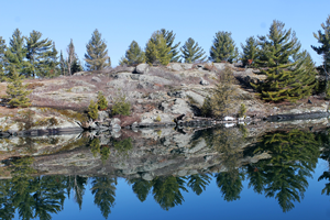 image of smooth water along rocky shoreline