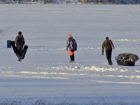 Image of ice fishermen walking on lake