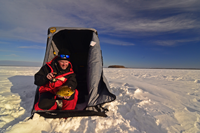 image of ice fisherman holding bluegill on the ice