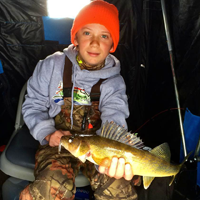 image of Dylan Kukkonen with Walleye in ice fishing shelter