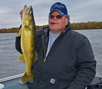 image of Kyle Reynolds holding a fat Lake Winnie Walleye