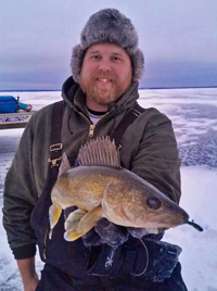 image of Austin Jones holding Walleye on The ice at Lake Winnie