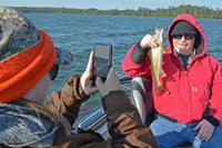 image of laura potter taking photo od dad with walleye