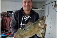 image of ice fisherman with big walleye